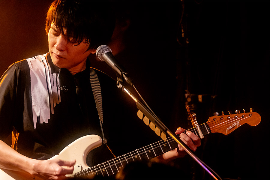 ステージで歌いながらギターを弾く斎藤宏介