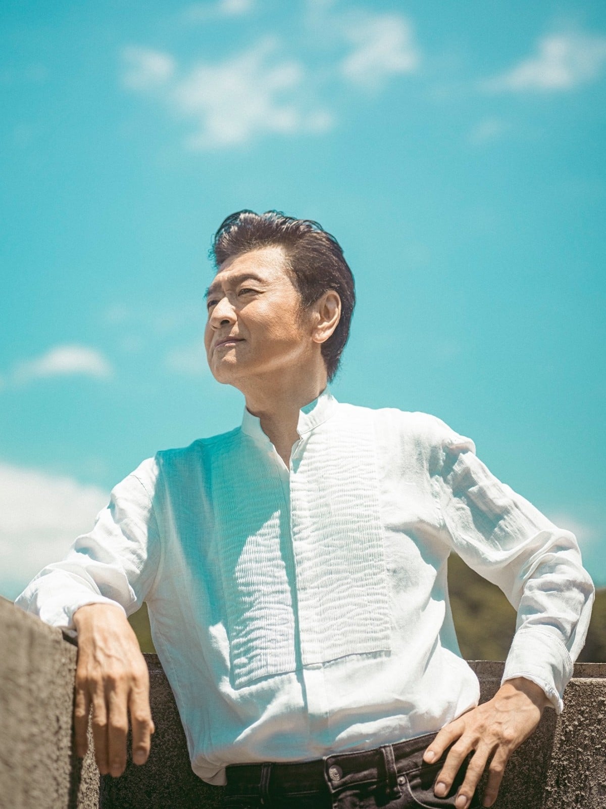 青空の下に立つ桑田佳祐さん