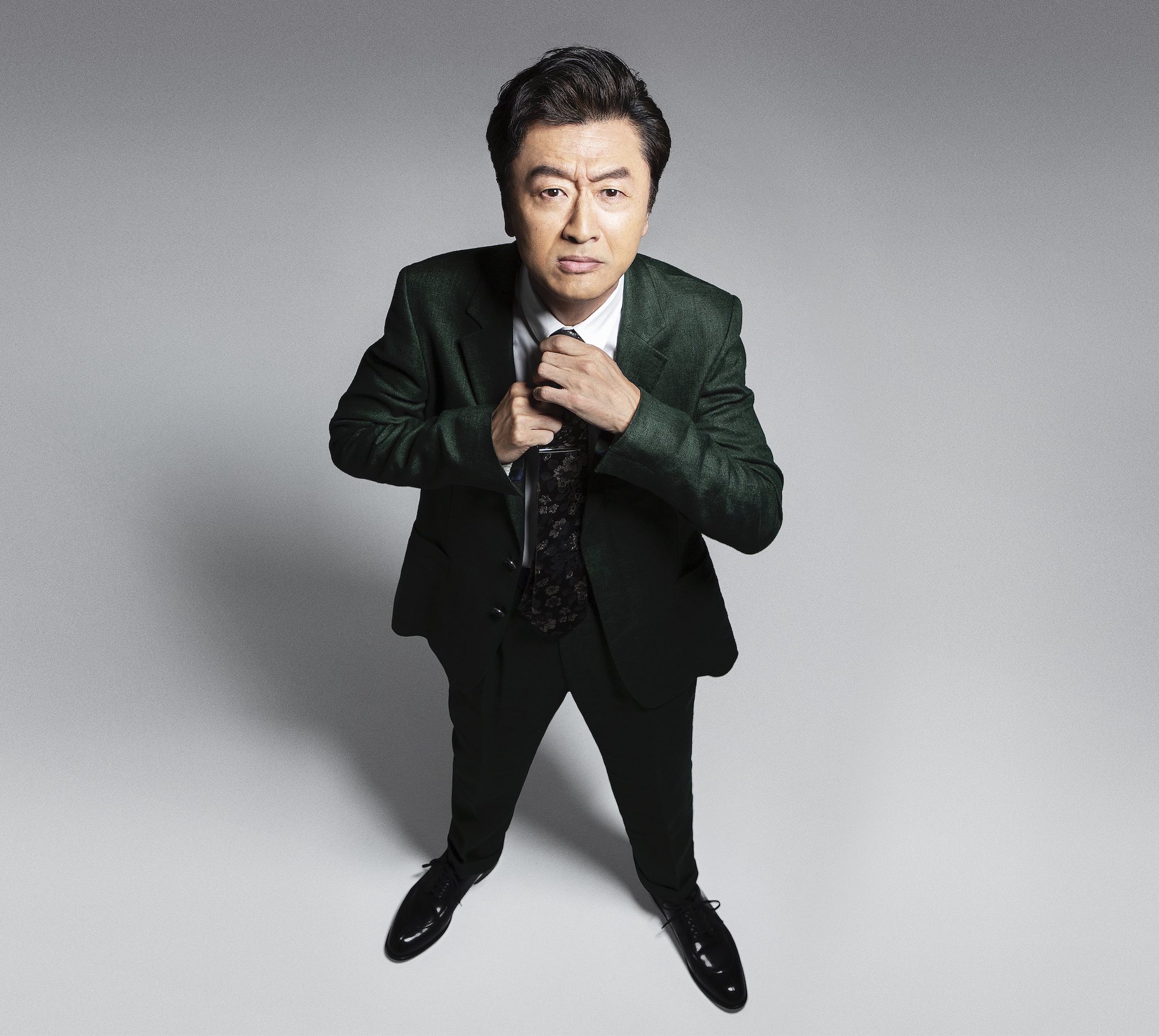 スーツ姿でカメラを見つめる桑田佳祐さん
