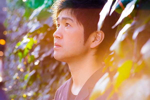 木々の中に立つ藤巻亮太