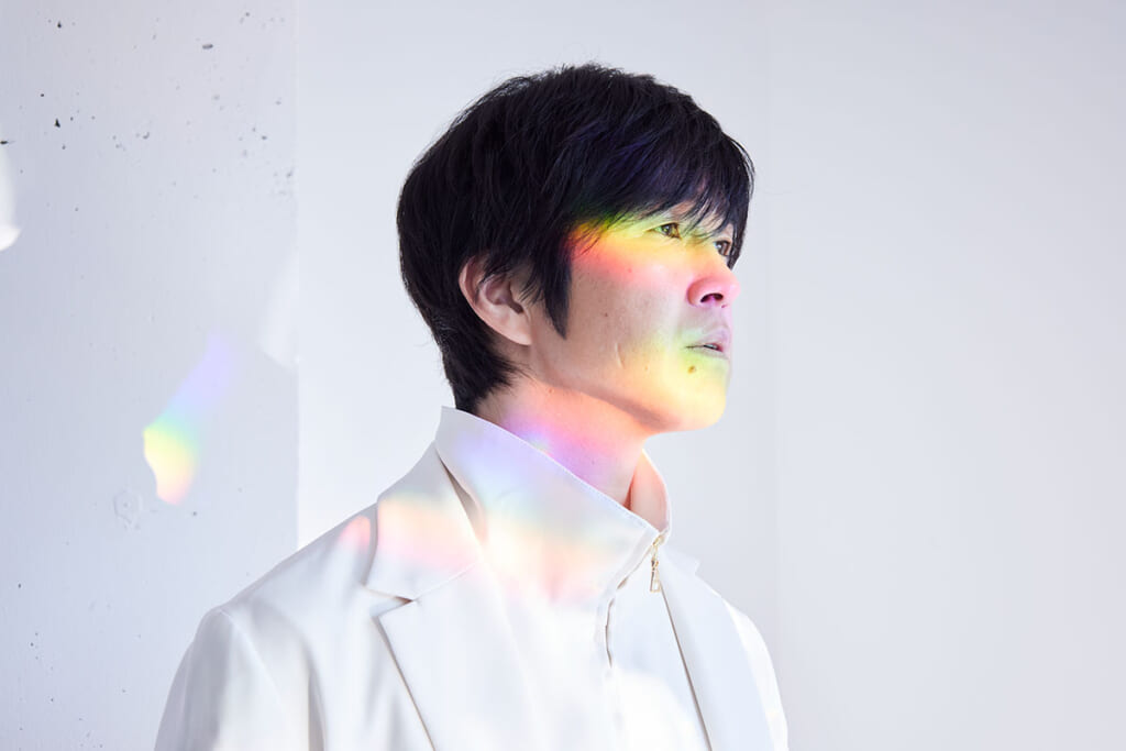 虹色の光を受ける藤巻亮太