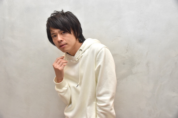 白いパーカを着て椅子に座る中川晃教