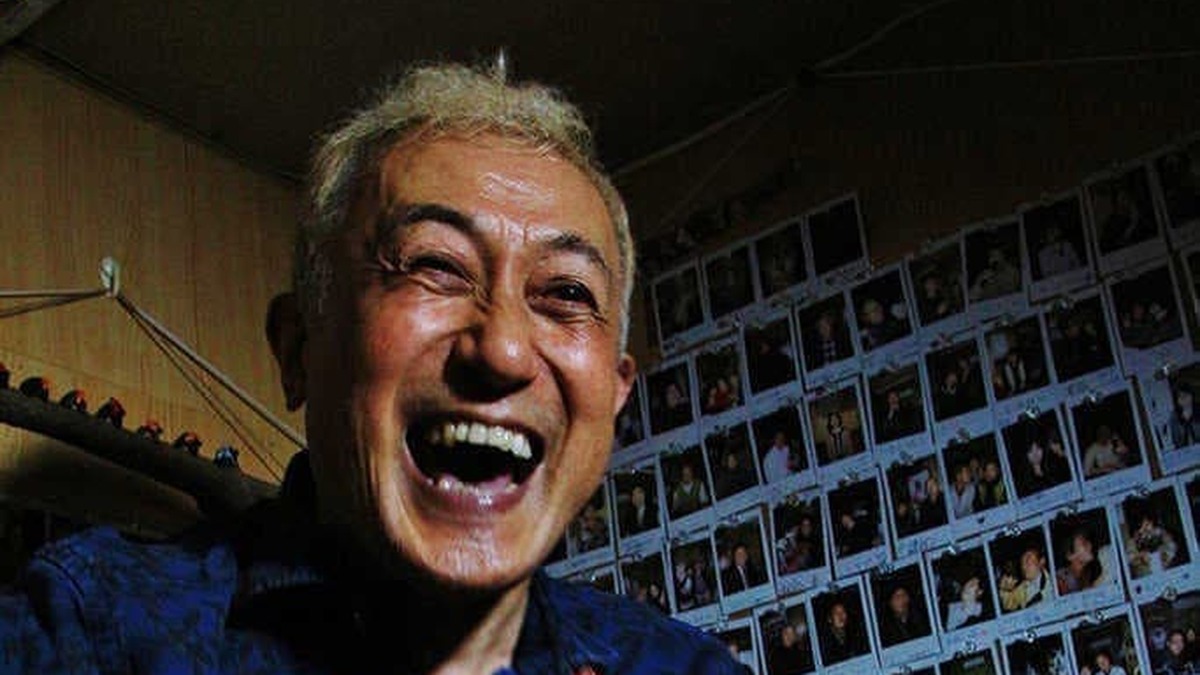 ギターを抱えて笑顔を見せる中川五郎
