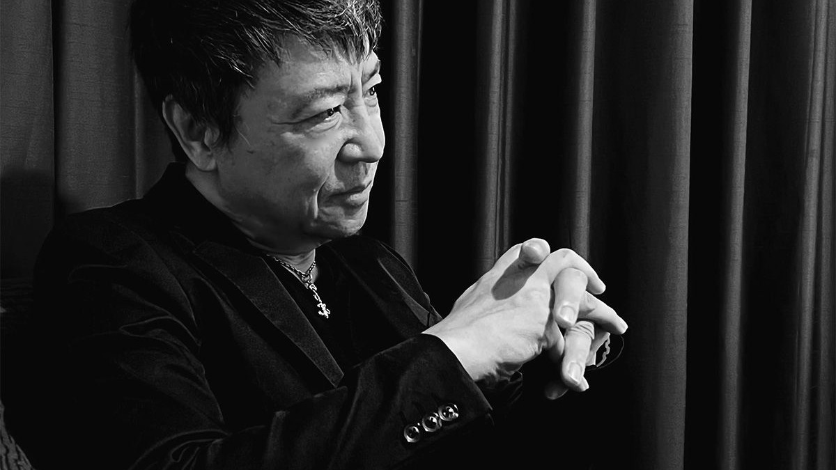 黒い服で横を向き語る世良公則