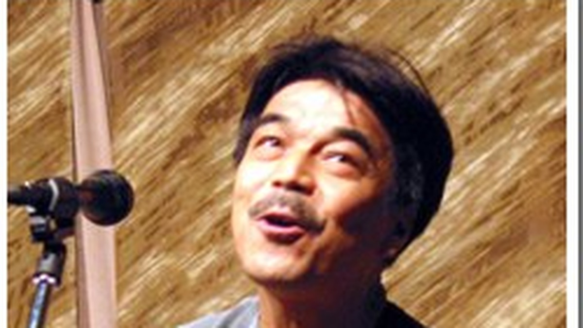 ギターを手に歌う加川良