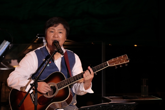 ギターを弾きながら歌う堀内孝雄