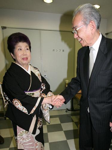2010年の引退会見で、夫の大村忠（右）と握手する二葉百合子（左）